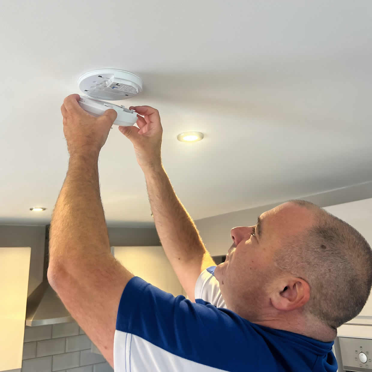 Smoke alarm being installed on a ceiling in Cwmbran